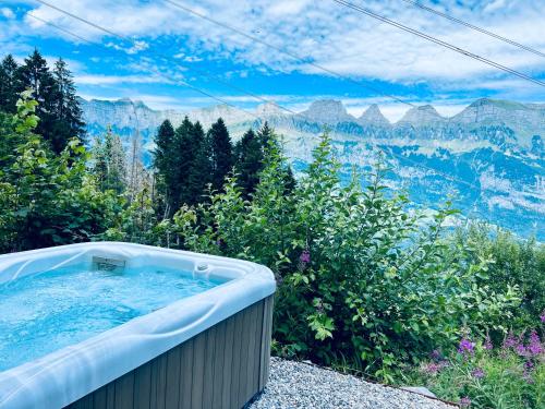 a hot tub with a view of the mountains at Chalet Wiesehockli - CharmingStay in Flumserberg