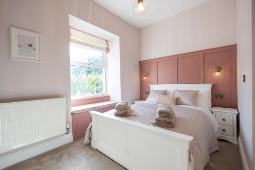 Un dormitorio con una cama blanca con toallas. en Siabod - Snowdonia, North Wales, en Bethesda
