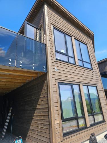 a house with glass windows on the side of it at Panorama view in Stranda
