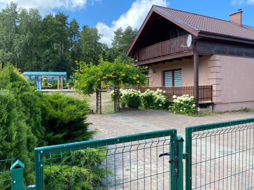 a house with a fence in front of it at Ranczo Słajszewo in Słajszewo
