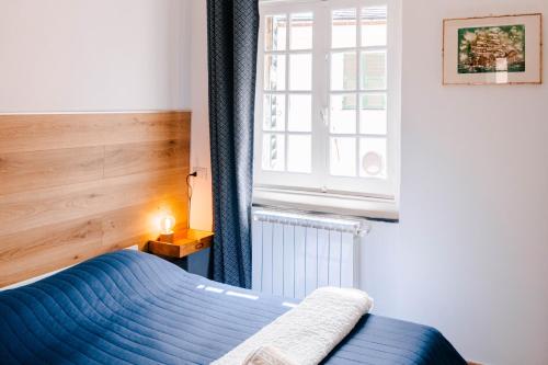 Un dormitorio con una cama azul y una ventana en Il Nido Luminoso Acquario-Genova Centro Storico, en Génova