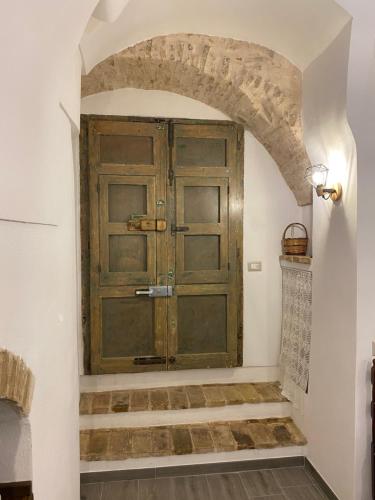 una gran puerta de madera en una habitación con escaleras en Casa Giovannina, en Bernalda
