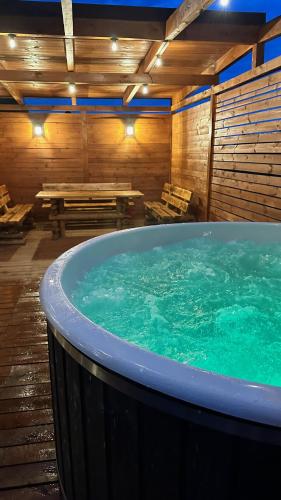 a large hot tub in a room with a picnic table at Ranczo Słajszewo in Słajszewo