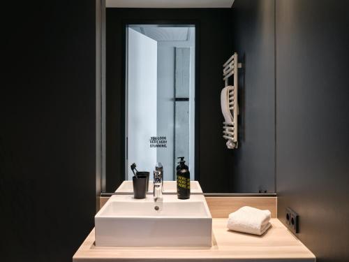a bathroom with a white sink and a mirror at STAYERY Bremen in Bremen