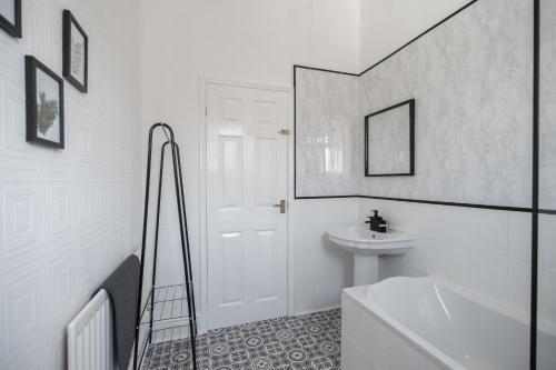 a white bathroom with a sink and a bath tub at Chelmsford House By Horizon Stays in Darlington