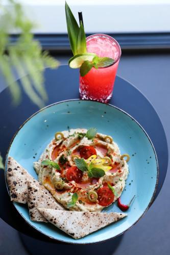 a plate of food on a table with a drink at VISIONAPARTMENTS Glattbrugg - contactless check-in in Glattbrugg