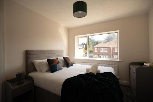 um quarto com uma cama grande e uma janela em Brinkburn House By Horizon Stays em Stockton-on-Tees