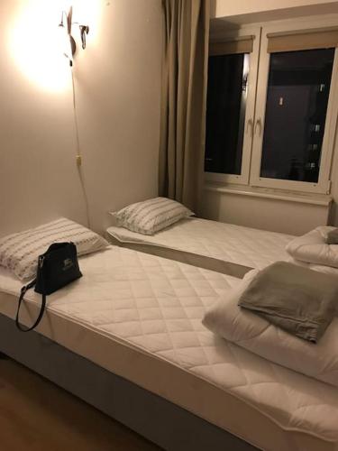 dos camas en un dormitorio con una bolsa sentada sobre ellas en Przytulny apartament z bezpłatnym parkingiem, en Olsztyn