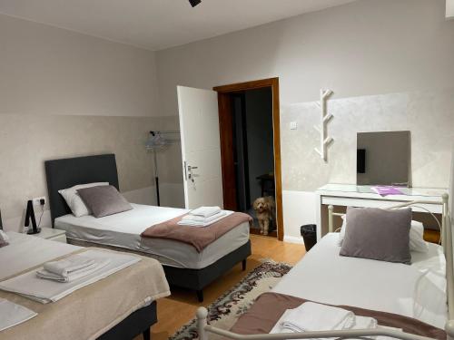 a bedroom with two beds and a desk and a mirror at MyHome2 in Subotica