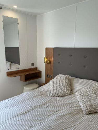 Luxury Seaside Cottage 28 في كنوك هايست: غرفة نوم بسرير كبير مع مرآة كبيرة