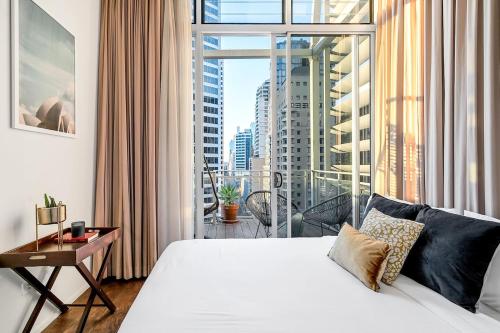 a bedroom with a white bed and a large window at Luxury Loft in the CBD with Outdoor Living in Sydney