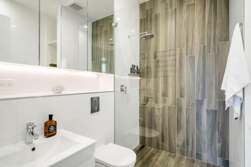a bathroom with a shower and a toilet and a sink at Luxury Loft in the CBD with Outdoor Living in Sydney