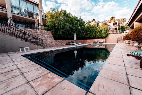 una piscina en un patio con una pared de ladrillo en Château La Mer Exclusive Guesthouse & Spa, en Hartbeespoort