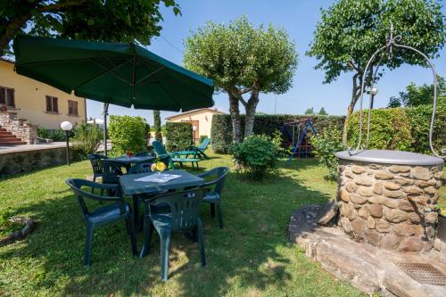 a patio with tables and chairs and an umbrella at B&B Maesta' Di Cudino in Arezzo