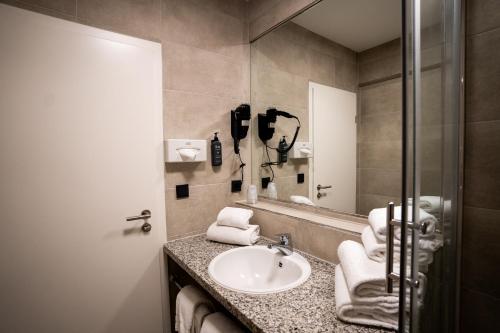 a bathroom with a sink and a mirror at AP Hotel Mannheim Viernheim in Viernheim