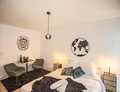 a bedroom with a bed and a desk and chairs at Voltaire Lion Suite - 5 min Hypercentre in Troyes