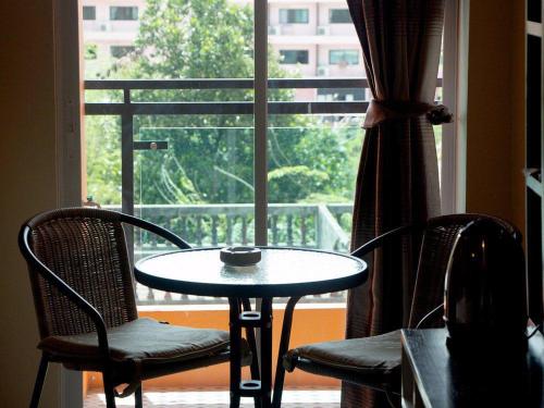 a table and chairs in front of a window at Lucky inn Residency in Pattaya South