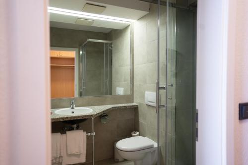 a bathroom with a toilet and a sink and a mirror at AP Hotel Mannheim Viernheim in Viernheim