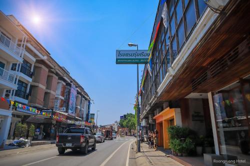 een vrachtwagen die door een straat met gebouwen rijdt bij Roongruang Hotel in Chiang Mai