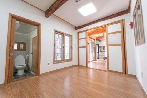 a bathroom with a toilet in a room with wooden floors at private house JNP stay in Seoul