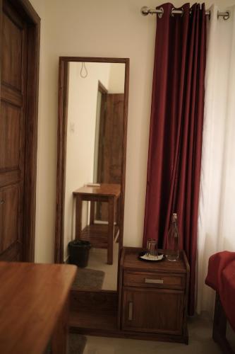 a room with a mirror and a wooden dresser and a table at SkyLounge Residency in Trivandrum