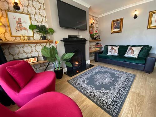 uma sala de estar com uma cadeira vermelha e uma lareira em Brighton Parlourama with Hot Tub - Sleeps 18 em Brighton & Hove