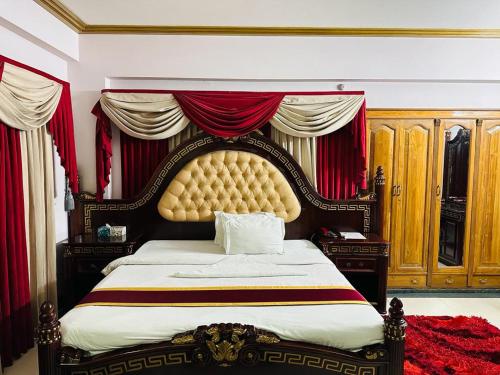 a bedroom with a large bed with a large headboard at Hotel Heaven Inn in Dhaka