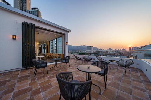 a patio with tables and chairs on the roof of a building at Brown Dot Hotel Daegu Suseong in Daegu