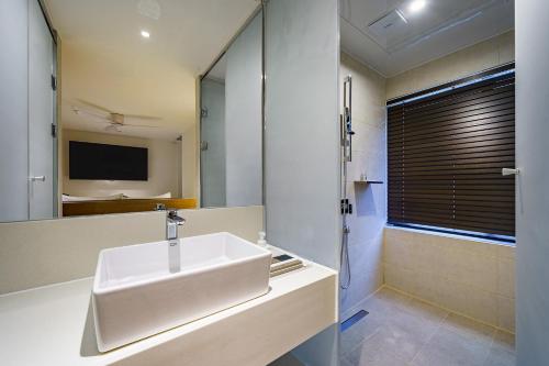 a bathroom with a sink and a shower with a mirror at Brown Dot Hotel Daegu Suseong in Daegu