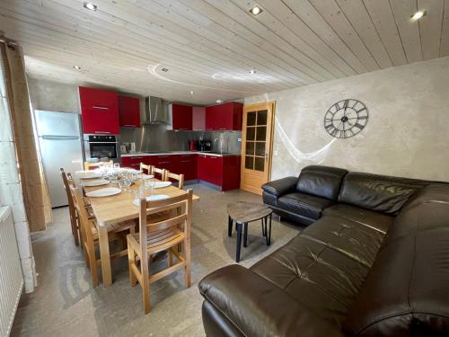 un salon avec un canapé et une table et une cuisine dans l'établissement Gentianes 1 - Très bel appartement centre village et proche des pistes, à La Clusaz