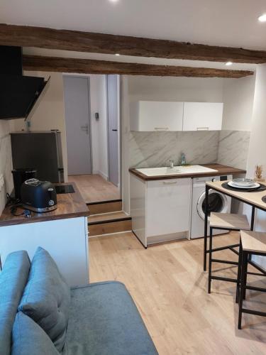 een woonkamer met een blauwe bank en een keuken bij Appartement, Langres in Langres