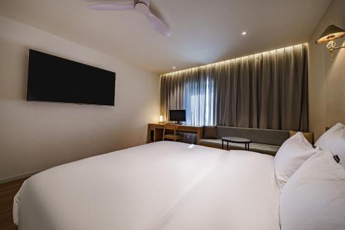 a hotel room with a bed and a flat screen tv at Brown Dot Hotel Daegu Suseong in Daegu