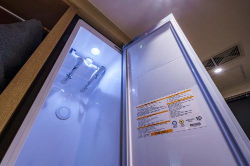 a shower in a bathroom with a sign on it at Brown Dot Hotel Daegu Suseong in Daegu