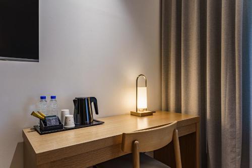 a desk with a lamp and a coffee maker on it at Brown Dot Hotel Daegu Suseong in Daegu