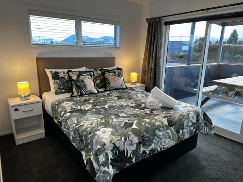 a bedroom with a bed and a large window at LH Twizel Fountain Retreat in Twizel