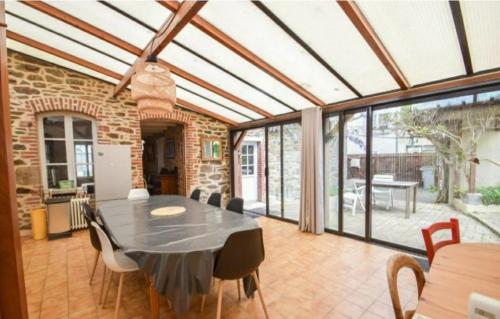 une véranda avec une table et des chaises noires dans l'établissement La Colline maison de famille à 100m de la Rance, à La Richardais