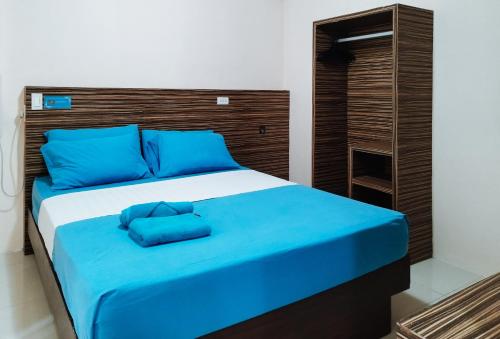 łóżko z niebieskimi poduszkami w pokoju w obiekcie RedDoorz at Sir G Hotel D'Mall Boracay w mieście Boracay