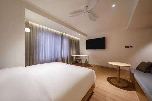 a bedroom with a bed and a tv and a couch at Brown Dot Hotel Daegu Suseong in Daegu