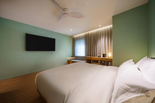 a bedroom with a white bed and a flat screen tv at Brown Dot Hotel Daegu Suseong in Daegu