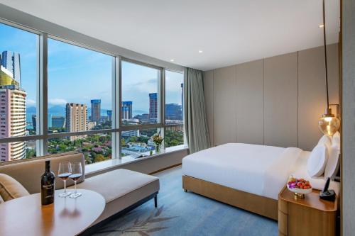 una camera d'albergo con un letto e una grande finestra di Kyushu Joycheng Hotel a Shenzhen