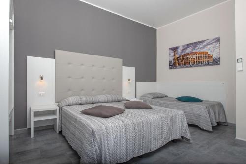 - une chambre avec 2 lits et un tableau mural dans l'établissement Hotel Assarotti, à Gênes