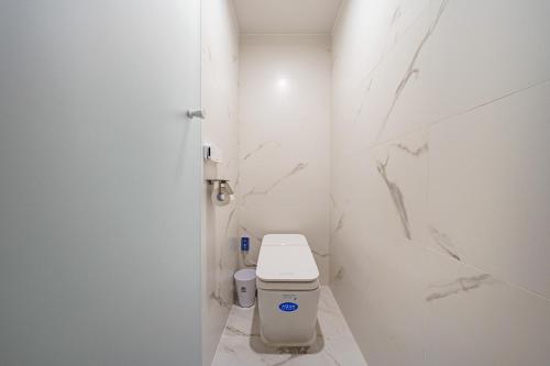 a white bathroom with a toilet in a stall at Brown Dot Hotel Daegu Suseong in Daegu