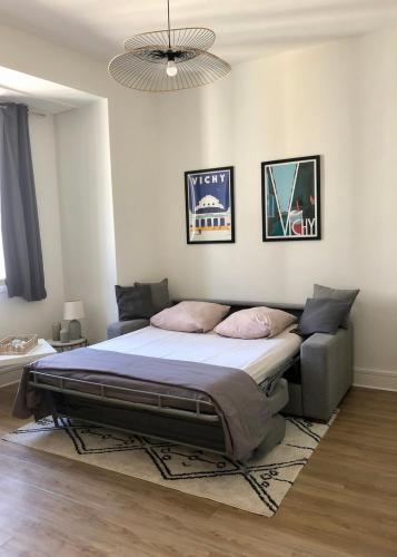 a bedroom with a large bed with a rug at Appartement Vichy - Hyper Centre in Vichy