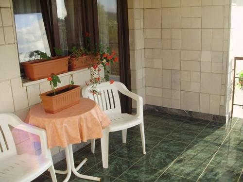 d'une table, de deux chaises et d'une table avec des fleurs. dans l'établissement Room in Sukosan with balcony, air conditioning, WiFi 5188-4, à Sukošan