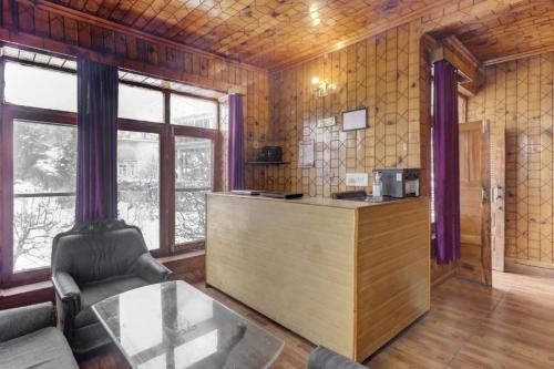 a kitchen with a counter in a room with windows at The Cozy Nook - Manali in Manāli