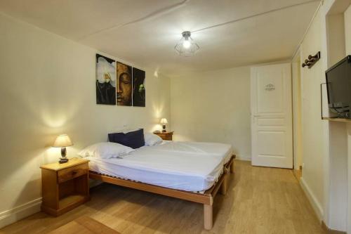 a bedroom with a bed and a flat screen tv at Aux volets bleus in Badonviller