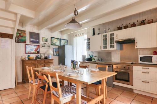 Il comprend une cuisine avec une table et des chaises en bois. dans l'établissement Maison pour 7 - 100m du port du Bono, au Bono