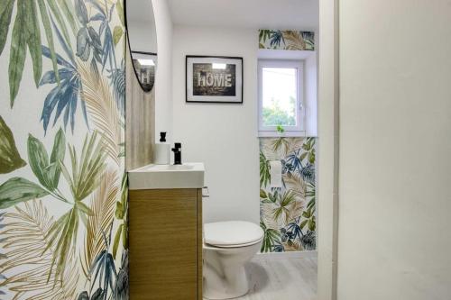 a bathroom with a toilet and a sink at Aux volets bleus in Badonviller