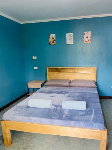 a bedroom with a bed with a blue wall at MUBA HOSTEL in Moalboal