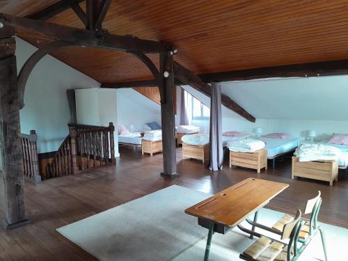 Cette chambre comprend 3 lits et une table en bois. dans l'établissement Maison Basque (24 pers), à Ascarat